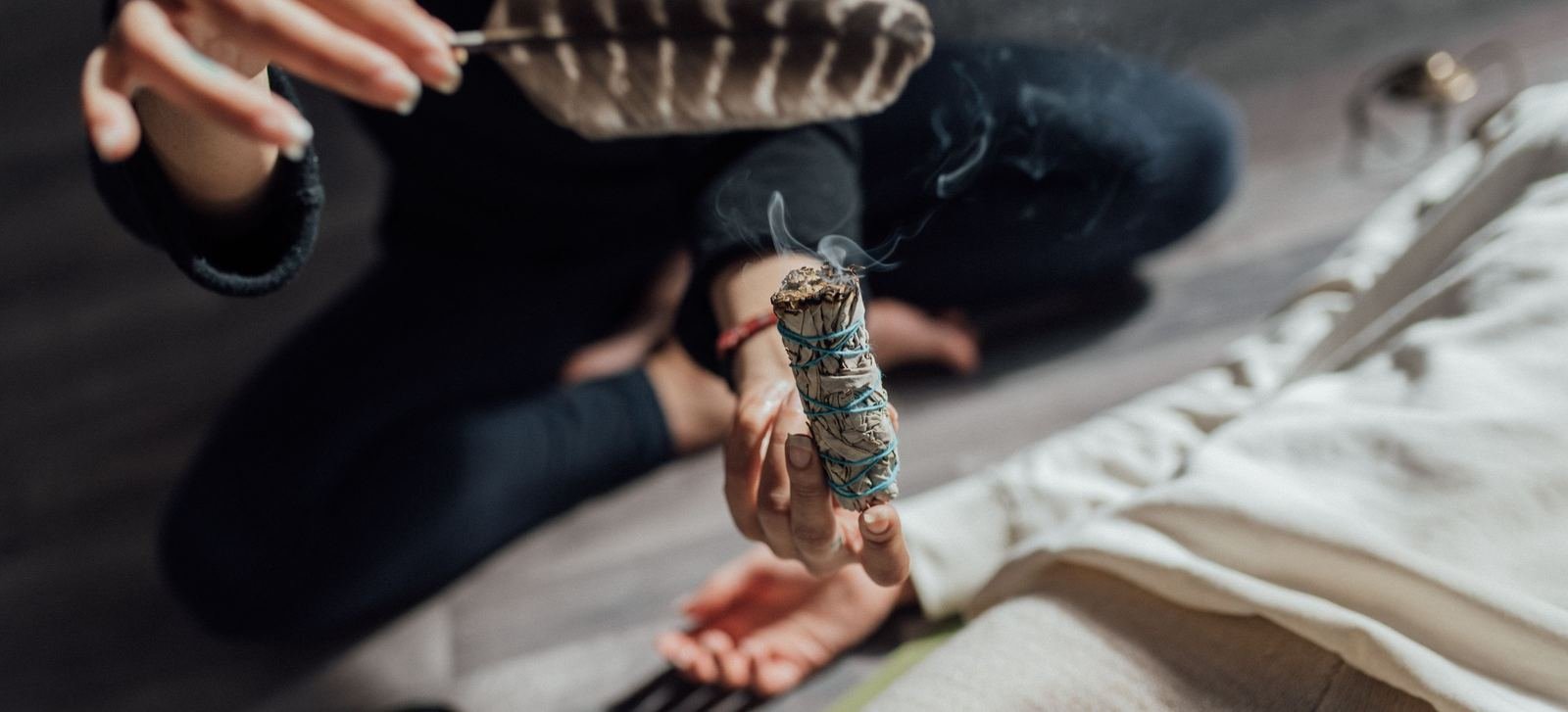 Ritual de limpieza con salvia humeante y una pluma